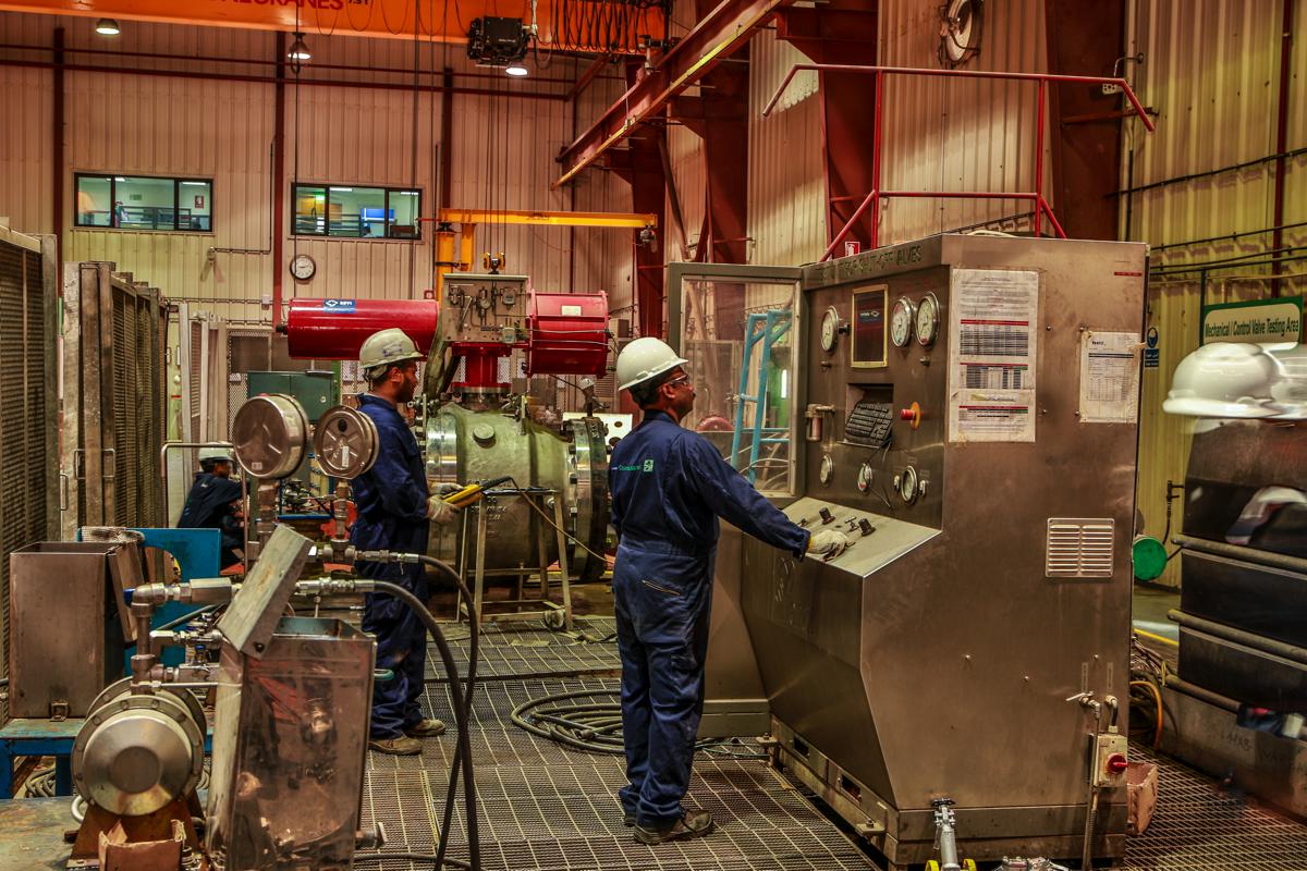 Two technicians at the test console in the mechanical and control valve testing area