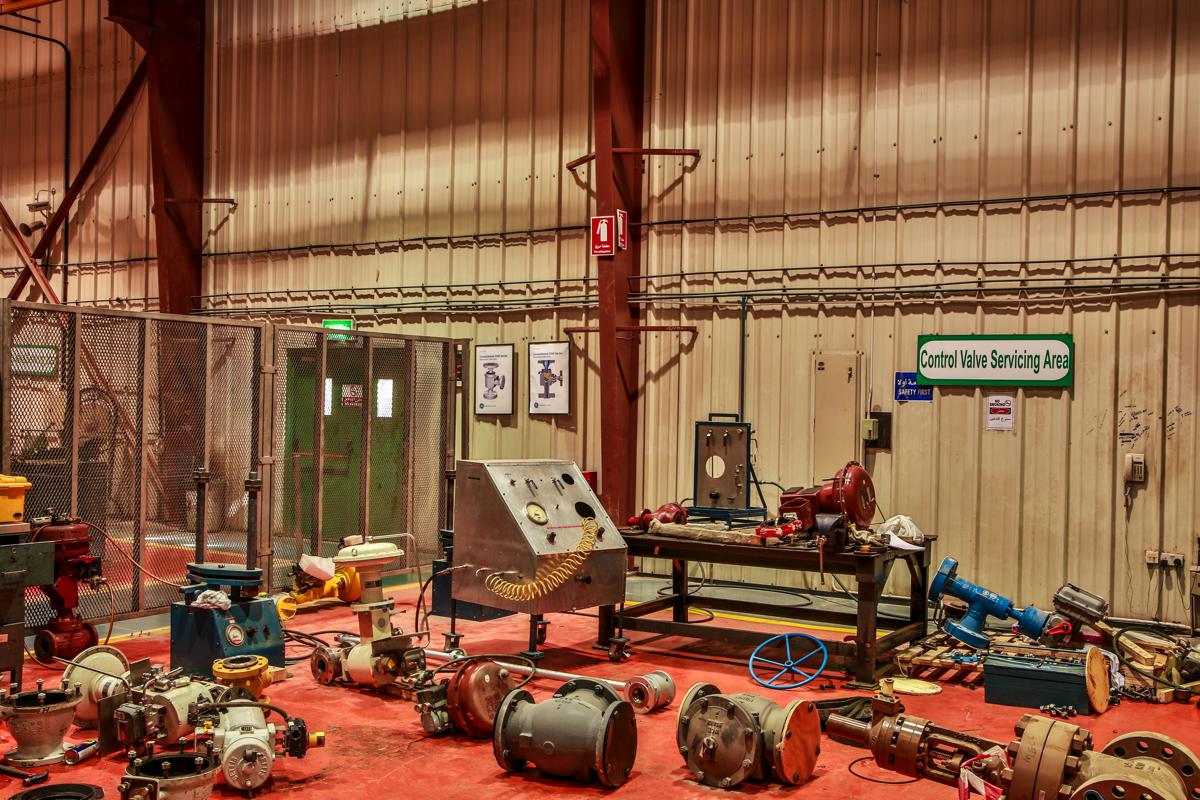 The control valve servicing area, with control valves and actuators laid out and a test console on the bench